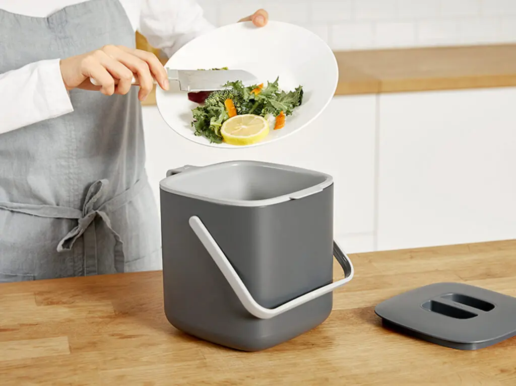 Best Compact Compost Container Bin - Image of putting food waste bin in the bin